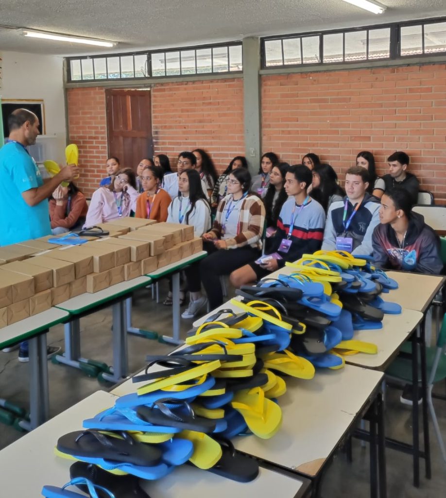 Confecção de chinelos e alunos olhando